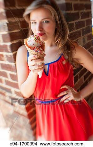 Portrait of a 22 year old brunette woman outdoors with an ice cream cone View Large Photo Image Picture - Portrait of a 22 year old brunette woman outdoors with an ice cream cone. Fotosearch