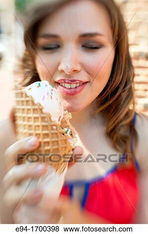 Portrait of a 22 year old brunette woman outdoors with an ice cream cone View Large Photo Image Stock Photo - Portrait of a 22 year old brunette woman outdoors with an ice cream cone. Fotosearch
