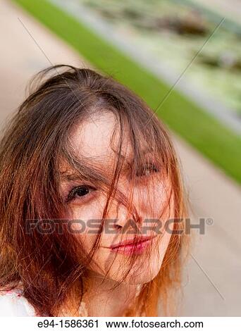Portrait of a 24 year old brunette woman with hair over her face looking at the camera at the camera View Large Photo Image Stock Image - Portrait of a 24 year old brunette woman with hair over her face looking at the camera at the camera. Fotosearch