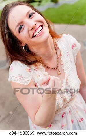Stock Photo - Portrait of a 24 year old brunette woman laughing at the camera. Fotosearch