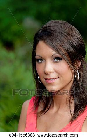 Portrait of a 25 year old brunette woman in a sleeveless dress in an outdoor garden setting. View Large Photo Image Stock Image - Portrait of a 25 year old brunette woman in a sleeveless dress in an outdoor garden setting.. Fotosearch