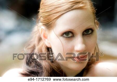 Portrait of a 25 year old redhead woman with dramatic make up and facial pierciengs outdoors View Large Photo Image Stock Photo - Portrait of a 25 year old redhead woman with dramatic make up and facial pierciengs outdoors. Fotosearch