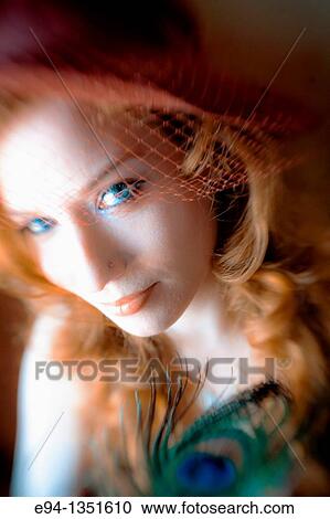 Portrait of a 28 year old redheaded woman wearing a hat with lace and holding a peacock feather looking at the camera. View Large Photo Image Stock Image - Portrait of a 28 year old redheaded woman wearing a hat with lace and holding a peacock feather looking at the camera.. Fotosearch
