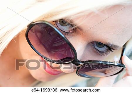 Portrait of a 29 year old blond woman outdoors, looking over sunglasses View Large Photo Image Stock Photograph - Portrait of a 29 year old blond woman outdoors, looking over sunglasses. Fotosearch