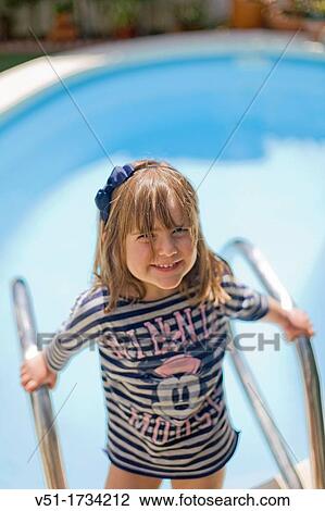 Stock Image - Portrait of a 3 years old girl in swimming pool. Fotosearch