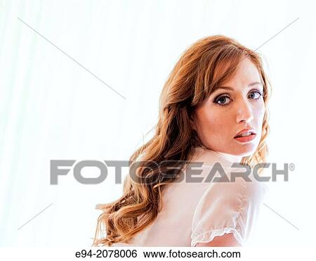 Portrait of a 31 year old redhead woman looking over her shoulder at the camera. View Large Photo Image Stock Photograph - Portrait of a 31 year old redhead woman looking over her shoulder at the camera.. Fotosearch