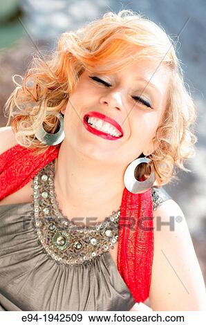 Stock Photo - Portrait of a 34 year old blond woman smiling with eyes closed.. Fotosearch