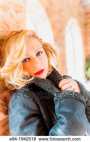 Stock Photo - Portrait of a 34 year old blond woman wearing a leather jacket looking at the camera.. Fotosearch
