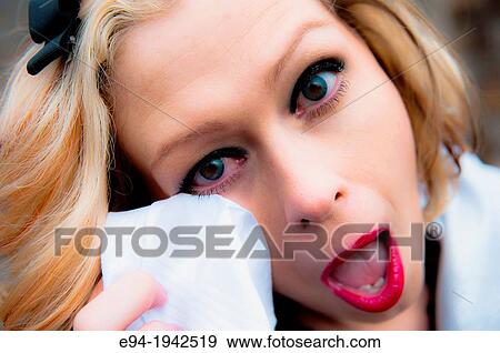 Portrait of a 34 year old blond woman looking at the camera holding a handkerchief to her face with her mouth open and eyes wide. View Large Photo Image Stock Photo - Portrait of a 34 year old blond woman looking at the camera holding a handkerchief to her face with her mouth open and eyes wide.. Fotosearch