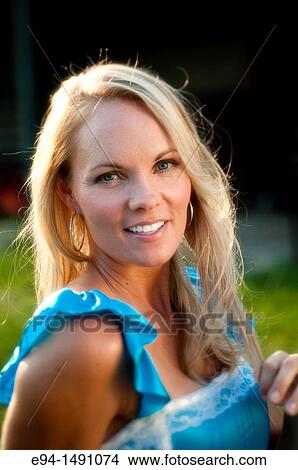 Portrait of a 35 year old blond woman in casual blue dress outdoors. View Large Photo Image Picture - Portrait of a 35 year old blond woman in casual blue dress outdoors.. Fotosearch