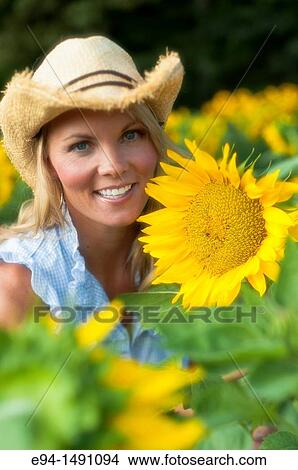 Portrait of a 35 year old blond woman with large sunflowers. View Large Photo Image Picture - Portrait of a 35 year old blond woman with large sunflowers.. Fotosearch