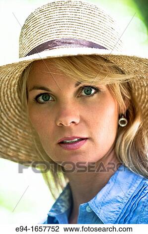 Portrait of a 35 year old blond woman wearing a straw hat and a blue blouse in a garden setting View Large Photo Image Stock Image - Portrait of a 35 year old blond woman wearing a straw hat and a blue blouse in a garden setting. Fotosearch