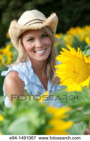 Portrait of a 35 year old blond woman with large sunflowers. View Large Photo Image Stock Photo - Portrait of a 35 year old blond woman with large sunflowers.. Fotosearch
