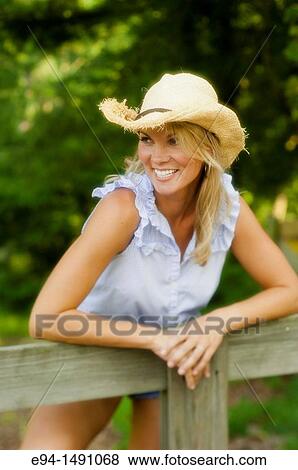 Portrait of a 35 year old blond woman with a straw hat leaning over a wooden rail fence in a country setting. View Large Photo Image Stock Photo - Portrait of a 35 year old blond woman with a straw hat leaning over a wooden rail fence in a country setting.. Fotosearch