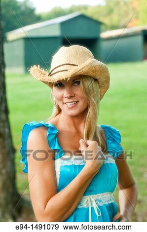 Portrait of a 35 year old blond woman in casual blue dress with a straw hat, outdoors in a country setting. View Large Photo Image Stock Photo - Portrait of a 35 year old blond woman in casual blue dress with a straw hat, outdoors in a country setting.. Fotosearch