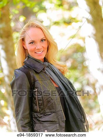 Portrait of a 38 year old blond woman smiling at the camera in a forest setting in the fall View Large Photo Image Stock Photo - Portrait of a 38 year old blond woman smiling at the camera in a forest setting in the fall. Fotosearch
