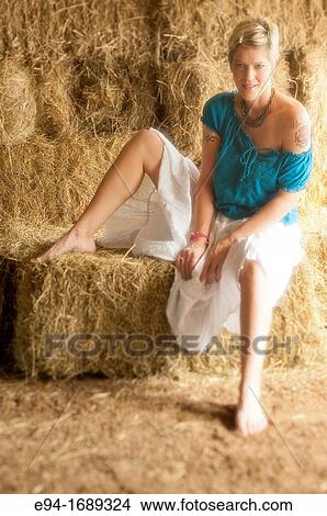 Portrait of a 41 year old blond woman looking at the camera reclining on hay bales in a barn View Large Photo Image Picture - Portrait of a 41 year old blond woman looking at the camera reclining on hay bales in a barn. Fotosearch