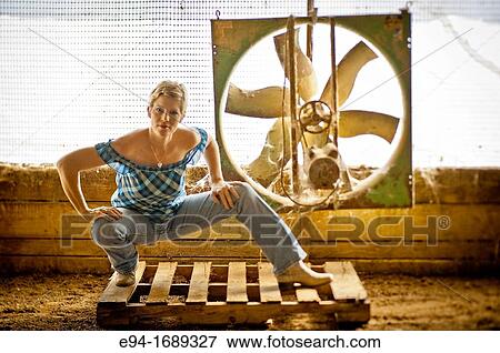 Portrait of a 41 year old blond woman looking at the camera wearing blue jeans in front of an old barn fan View Large Photo Image Stock Photo - Portrait of a 41 year old blond woman looking at the camera wearing blue jeans in front of an old barn fan. Fotosearch
