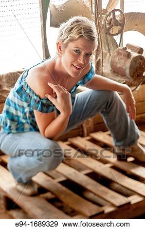 Portrait of a 41 year old blond woman looking at the camera wearing blue jeans in front of an old barn fan View Large Photo Image Stock Photo - Portrait of a 41 year old blond woman looking at the camera wearing blue jeans in front of an old barn fan. Fotosearch