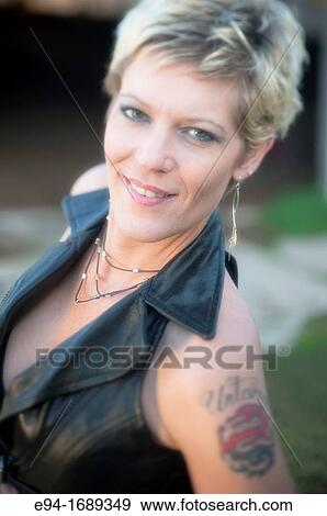 Portrait of a 41 year old blond woman smiling at the camera, tattoo on shoulder View Large Photo Image Stock Photo - Portrait of a 41 year old blond woman smiling at the camera, tattoo on shoulder. Fotosearch