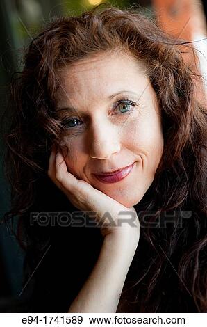 Portrait Of A 42 Year Old Woman With Long Curly Black Hair Smiling