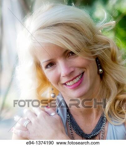 Portrait of a 44 year old blond woman, outdoors View Large Photo Image Stock Image - Portrait of a 44 year old blond woman, outdoors. Fotosearch