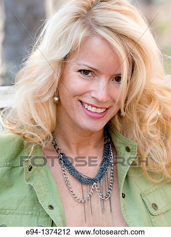 Stock Image - Portrait of a 44 year old blond woman, outdoors. Fotosearch