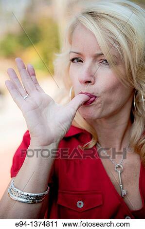 Portrait of a 44 year old blond woman licking her thumb, outdoors View Large Photo Image Stock Image - Portrait of a 44 year old blond woman licking her thumb, outdoors. Fotosearch
