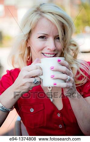 Portrait of a 44 year old blond woman holding a coffee cup, outdoors View Large Photo Image Stock Photo - Portrait of a 44 year old blond woman holding a coffee cup, outdoors. Fotosearch