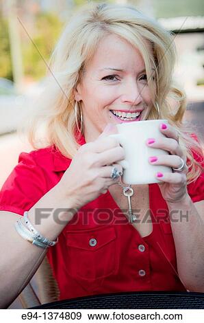 Portrait of a 44 year old blond woman holding a coffee cup, outdoors View Large Photo Image Stock Photo - Portrait of a 44 year old blond woman holding a coffee cup, outdoors. Fotosearch