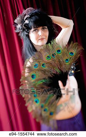 Portrait of a 45 year old brunette woman in an exotic costume with a peacock feather fan View Large Photo Image Picture - Portrait of a 45 year old brunette woman in an exotic costume with a peacock feather fan. Fotosearch