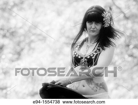 Stock Photo - Portrait of a 45 year old brunette woman in an exotic costume outdoors. Fotosearch