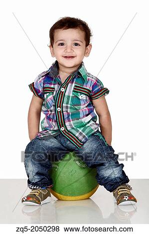Portrait of a 5 year old indian boy seating on ball, Pune India View Large Photo Image Stock Photo - Portrait of a 5 year old indian boy seating on ball, Pune India. Fotosearch