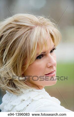 Portrait of a 50 year old blond woman in an outdoor setting smiling at the camera View Large Photo Image Stock Image - Portrait of a 50 year old blond woman in an outdoor setting smiling at the camera. Fotosearch