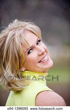 Portrait of a 50 year old blond woman in an outdoor setting smiling at the camera View Large Photo Image Stock Image - Portrait of a 50 year old blond woman in an outdoor setting smiling at the camera. Fotosearch