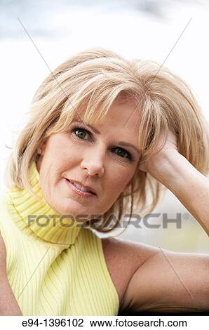 Portrait of a 50 year old blond woman in an outdoor setting smiling at the camera View Large Photo Image Stock Image - Portrait of a 50 year old blond woman in an outdoor setting smiling at the camera. Fotosearch