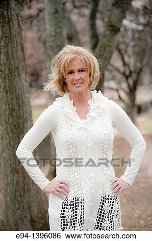 Portrait of a 50 year old blond woman in an outdoor setting smiling at the camera View Large Photo Image Stock Photograph - Portrait of a 50 year old blond woman in an outdoor setting smiling at the camera. Fotosearch