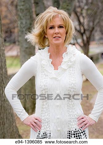 Portrait of a 50 year old blond woman in an outdoor setting smiling at the camera View Large Photo Image Stock Photography - Portrait of a 50 year old blond woman in an outdoor setting smiling at the camera. Fotosearch