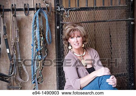 Portrait of a 52 year old blonde woman in casual clothing in a horse barn setting looking at the camera. View Large Photo Image Stock Image - Portrait of a 52 year old blonde woman in casual clothing in a horse barn setting looking at the camera.. Fotosearch
