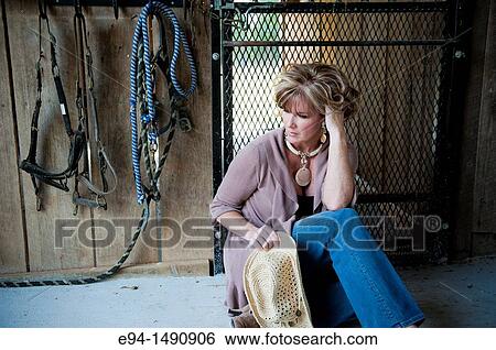 Portrait of a 52 year old blonde woman in casual clothing in a horse barn setting looking away from the camera. View Large Photo Image Stock Photograph - Portrait of a 52 year old blonde woman in casual clothing in a horse barn setting looking away from the camera.. Fotosearch