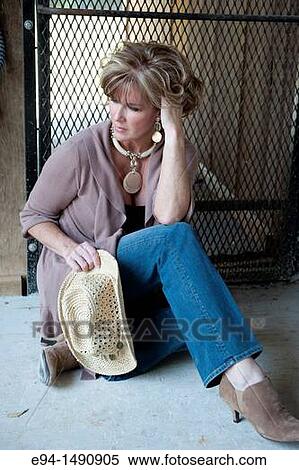 Portrait of a 52 year old blonde woman in casual clothing in a horse barn setting looking away from the camera. View Large Photo Image Stock Photography - Portrait of a 52 year old blonde woman in casual clothing in a horse barn setting looking away from the camera.. Fotosearch