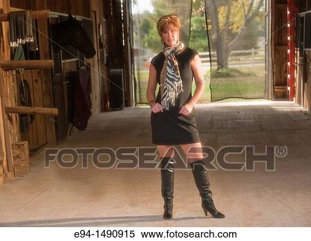 Portrait of a 52 year old blonde woman in casual black dress in a horse barn setting looking at the camera. View Large Photo Image Stock Photography - Portrait of a 52 year old blonde woman in casual black dress in a horse barn setting looking at the camera.. Fotosearch