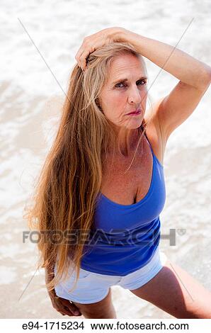 Portrait of a 57 year old woman on a beach looking at the camera View Large Photo Image Picture - Portrait of a 57 year old woman on a beach looking at the camera. Fotosearch