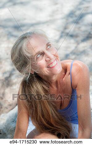 Portrait of a 57 year old woman on a beach smiling away from the camera View Large Photo Image Stock Image - Portrait of a 57 year old woman on a beach smiling away from the camera. Fotosearch
