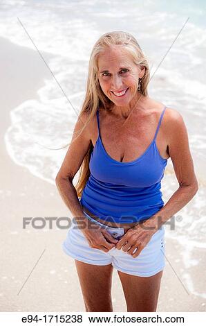 Portrait of a 57 year old woman on a beach smiling at the camera View Large Photo Image Stock Photo - Portrait of a 57 year old woman on a beach smiling at the camera. Fotosearch