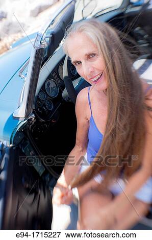 Portrait of a 57 year old woman sitting in her MG car at a beach View Large Photo Image Stock Photo - Portrait of a 57 year old woman sitting in her MG car at a beach. Fotosearch