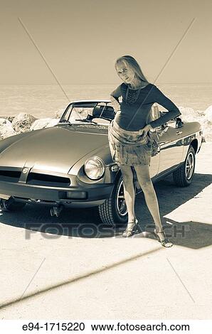 Portrait of a 57 year old woman standing by her MG car at a beach View Large Photo Image Stock Image - Portrait of a 57 year old woman standing by her MG car at a beach. Fotosearch