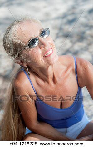 Portrait of a 57 year old woman wearing sunglasses at the beach View Large Photo Image Stock Photo - Portrait of a 57 year old woman wearing sunglasses at the beach. Fotosearch
