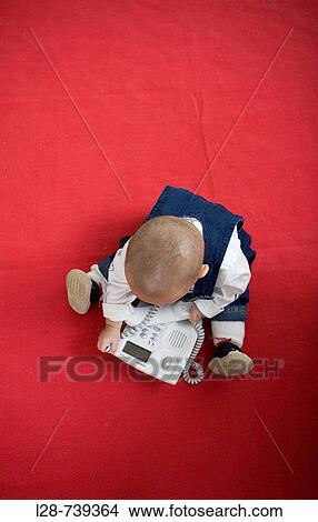 Picture - Portrait of a baby holding telephone. Fotosearch