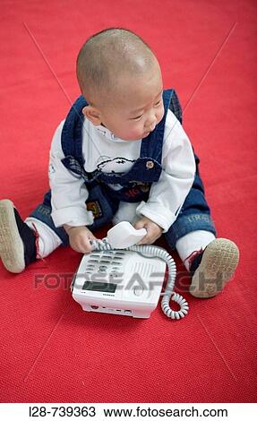 Portrait of a baby holding telephone View Large Photo Image Stock Image - Portrait of a baby holding telephone. Fotosearch